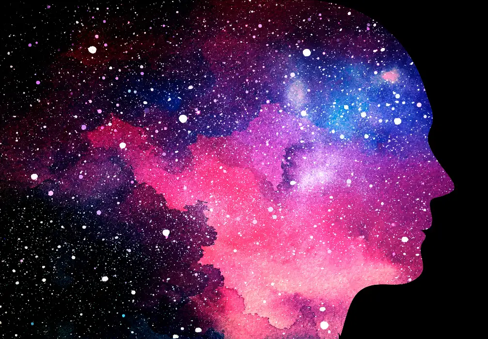 outline of a persons head filled with stars and the universe with pinks, blues and purples of colour